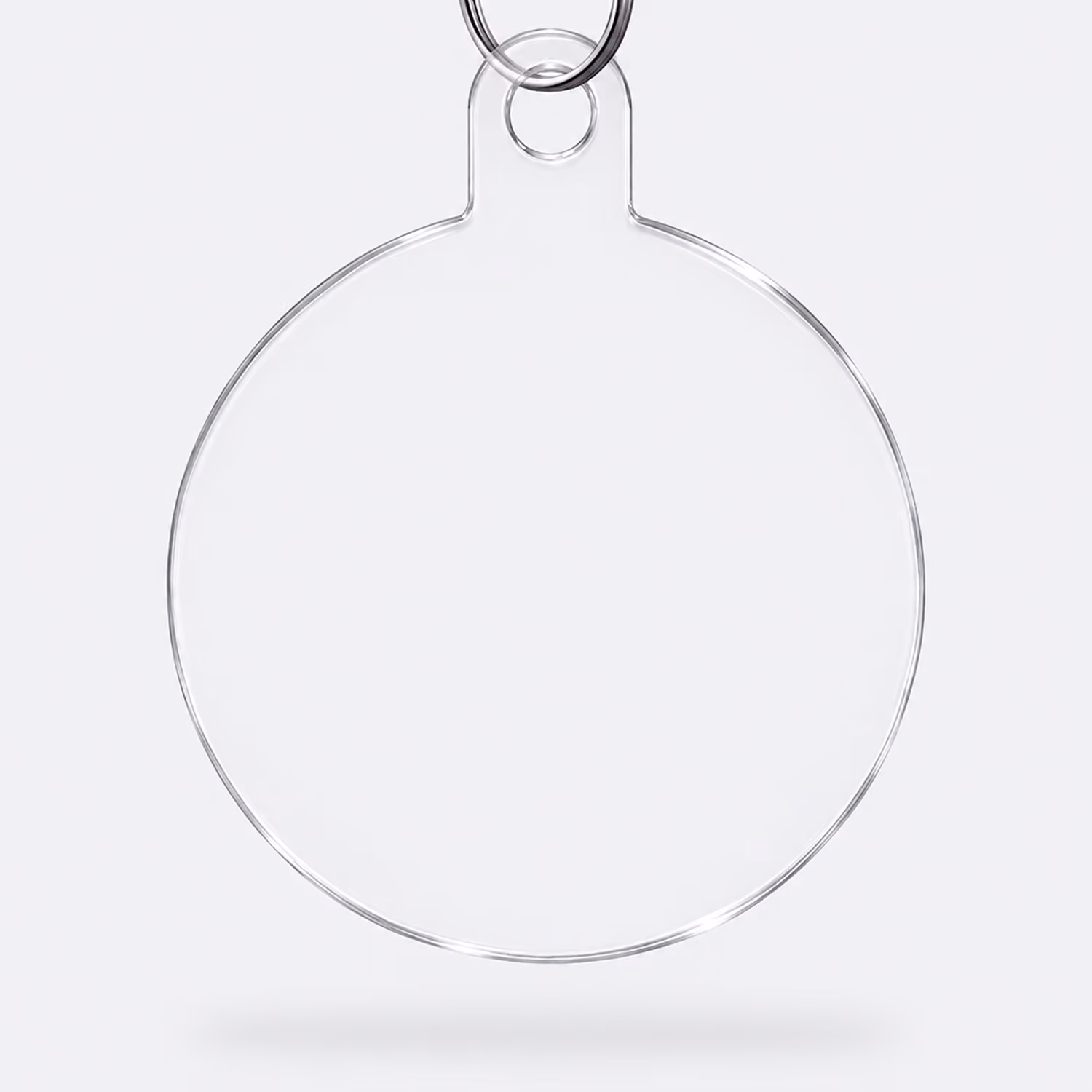 Clear round keychain with a metal ring, isolated on a light gray background.