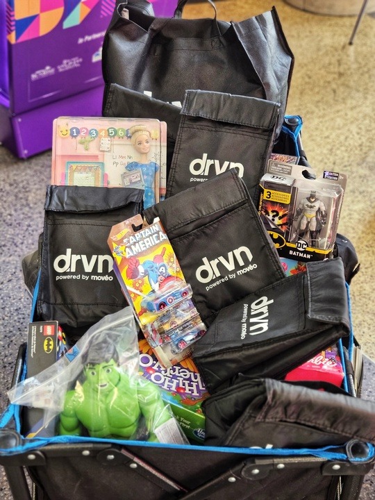 A bunch of goodie bags with the drvn logo on them inside of a cart.