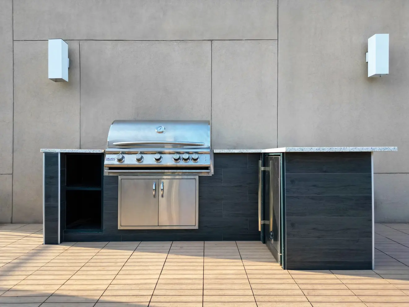 Stainless steel outdoor kitchen with granite countertop on a Greenpoint rooftop deck with composite deck tiles.