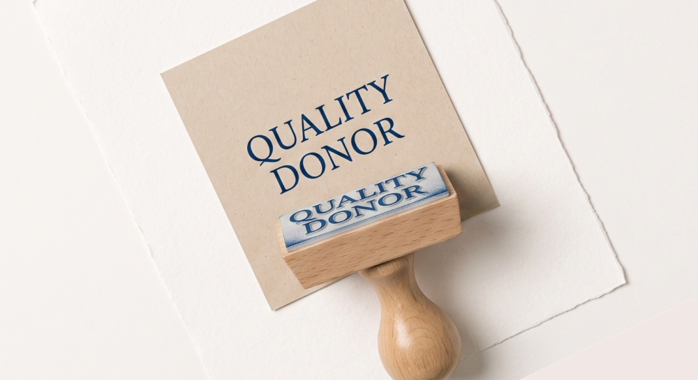 Rubber stamp and paper both showing the text 'QUALITY DONOR' in blue letters.