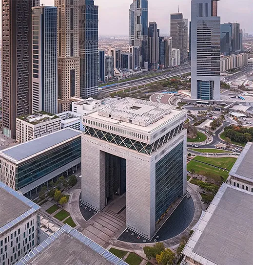 A woman in business attire working on a laptop, with digital stock market data reflected on the screen. She appears focused on analyzing the fluctuating lines and graphs.
