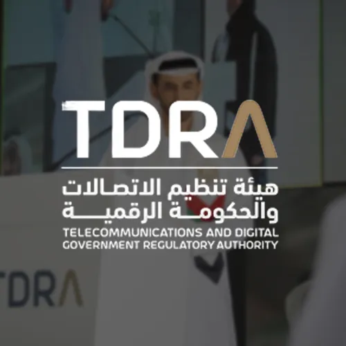 The TDRA logo, with the acronym in bold and the full name written in both English and Arabic below it. The background shows a government official speaking at a podium, representing regulatory authority in telecommunications and digital governance.