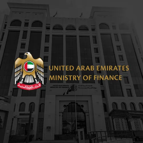 The Ministry of Finance logo of the United Arab Emirates, featuring a golden eagle with the UAE flag on its chest. The words "United Arab Emirates Ministry of Finance" are written below in both English and Arabic, against a backdrop of the ministry's headquarters.