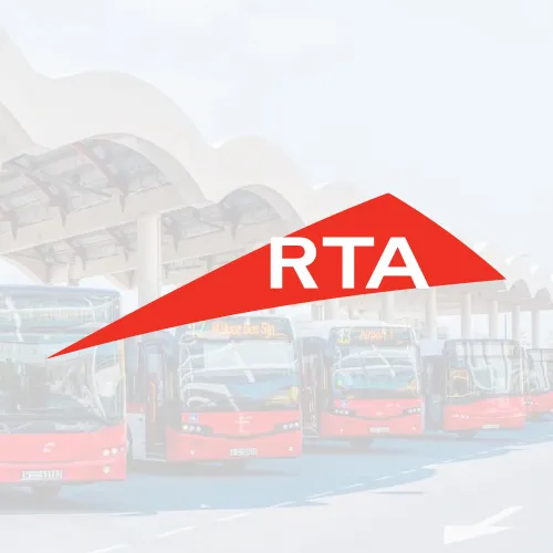 A red triangular logo representing the RTA, with the words "RTA" prominently displayed. The background features a bus station and buses, highlighting public transport and infrastructure in Dubai.