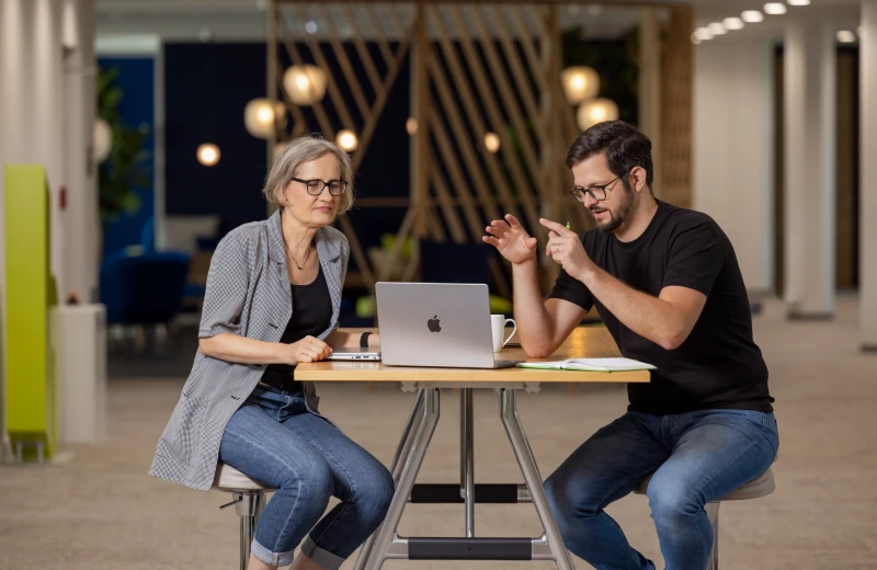 Kollaoratives lernen im Unternehmen: Zwei Mitarbeitende tauschen sich über Ihre Lernerfahrungen aus