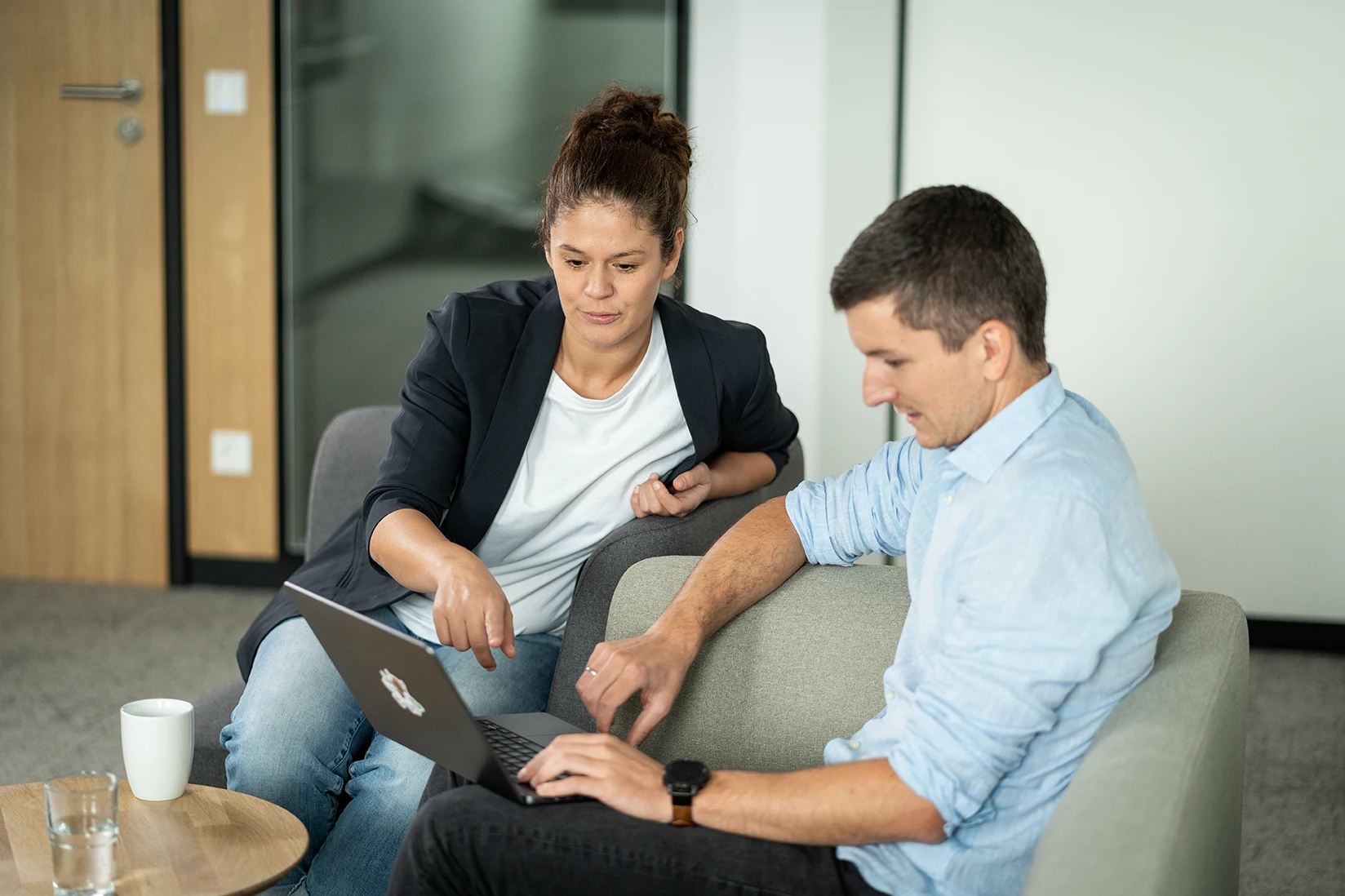 Zwei Personen arbeiten gemeinsam an einem Laptop