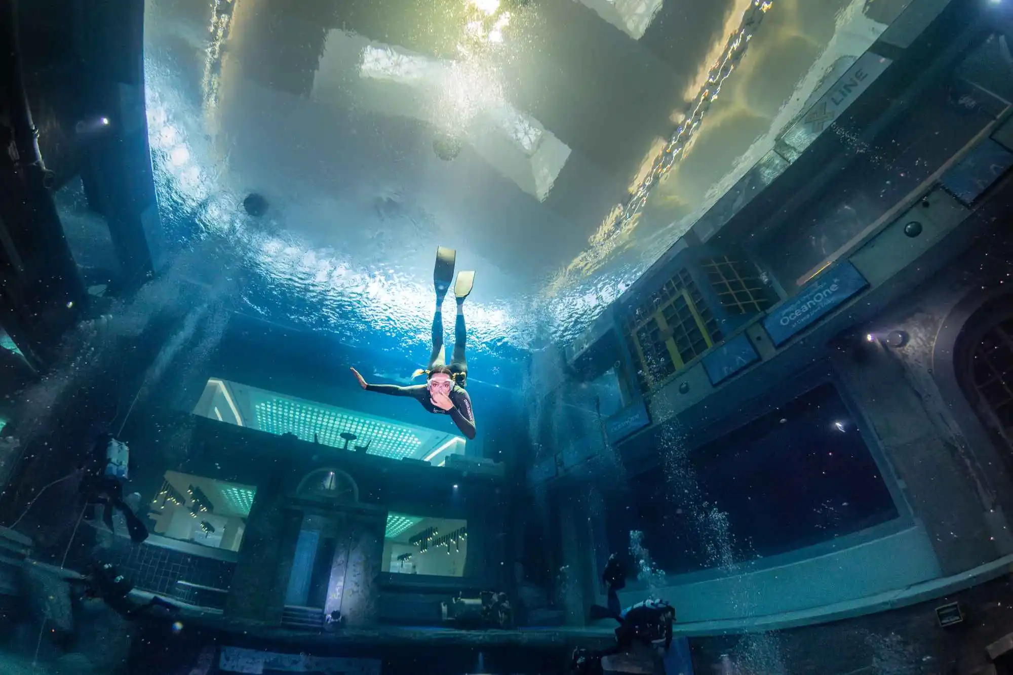 a person swimming underwater in a large tank