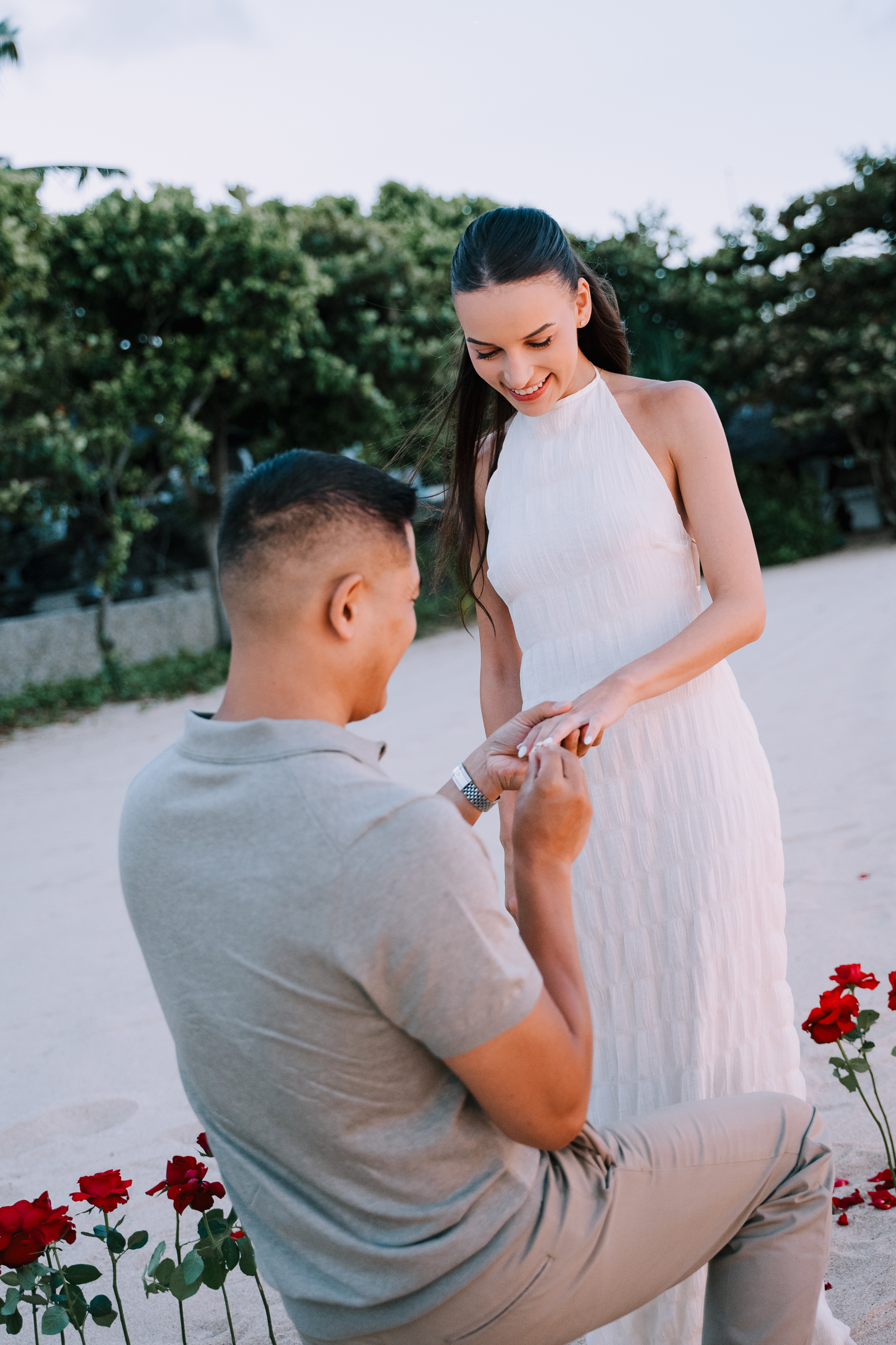 Groom dropping to one knee for a surprise helicopter proposal on a private Bali cliffside.