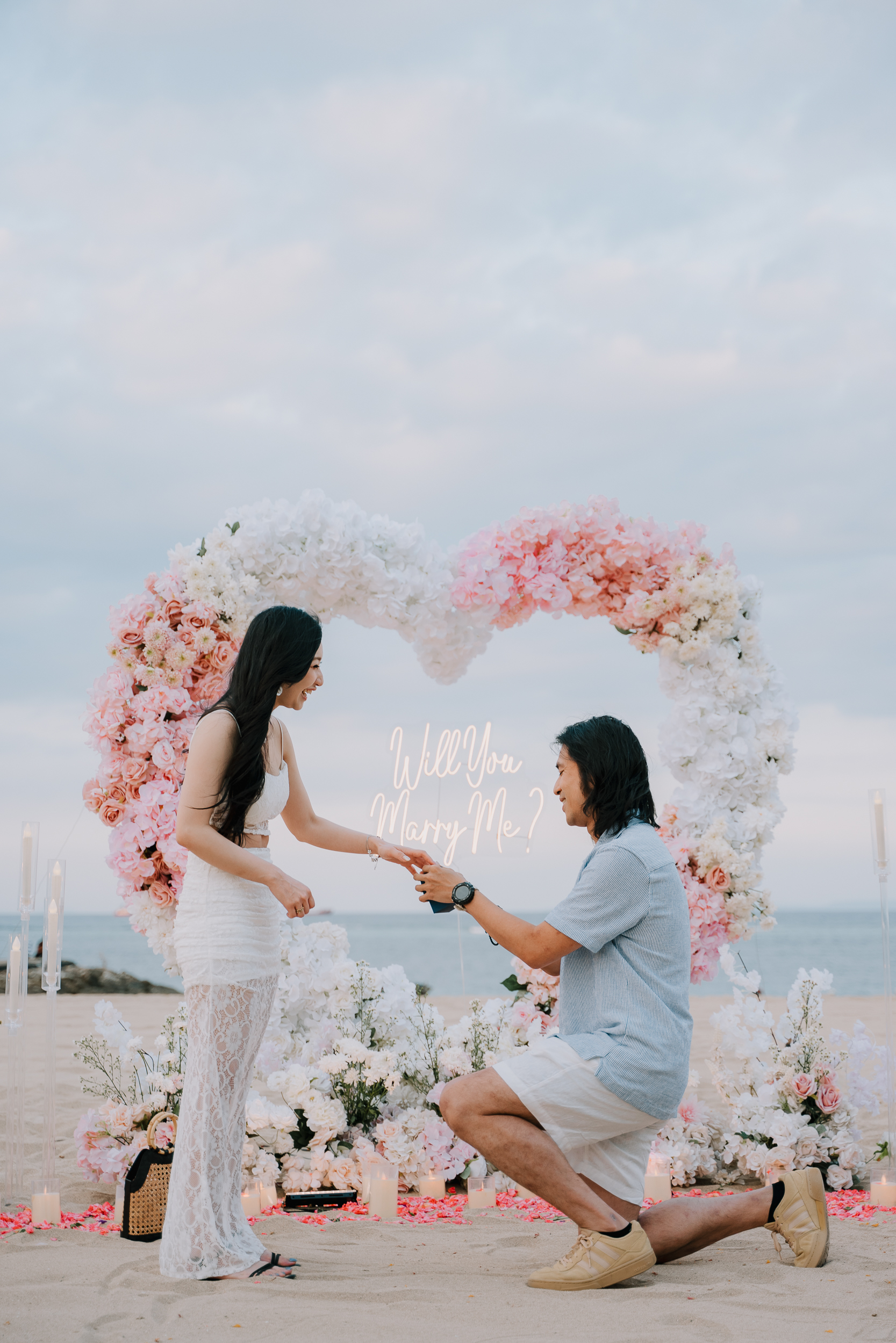 Groom dropping to one knee for a surprise helicopter proposal on a private Bali cliffside.