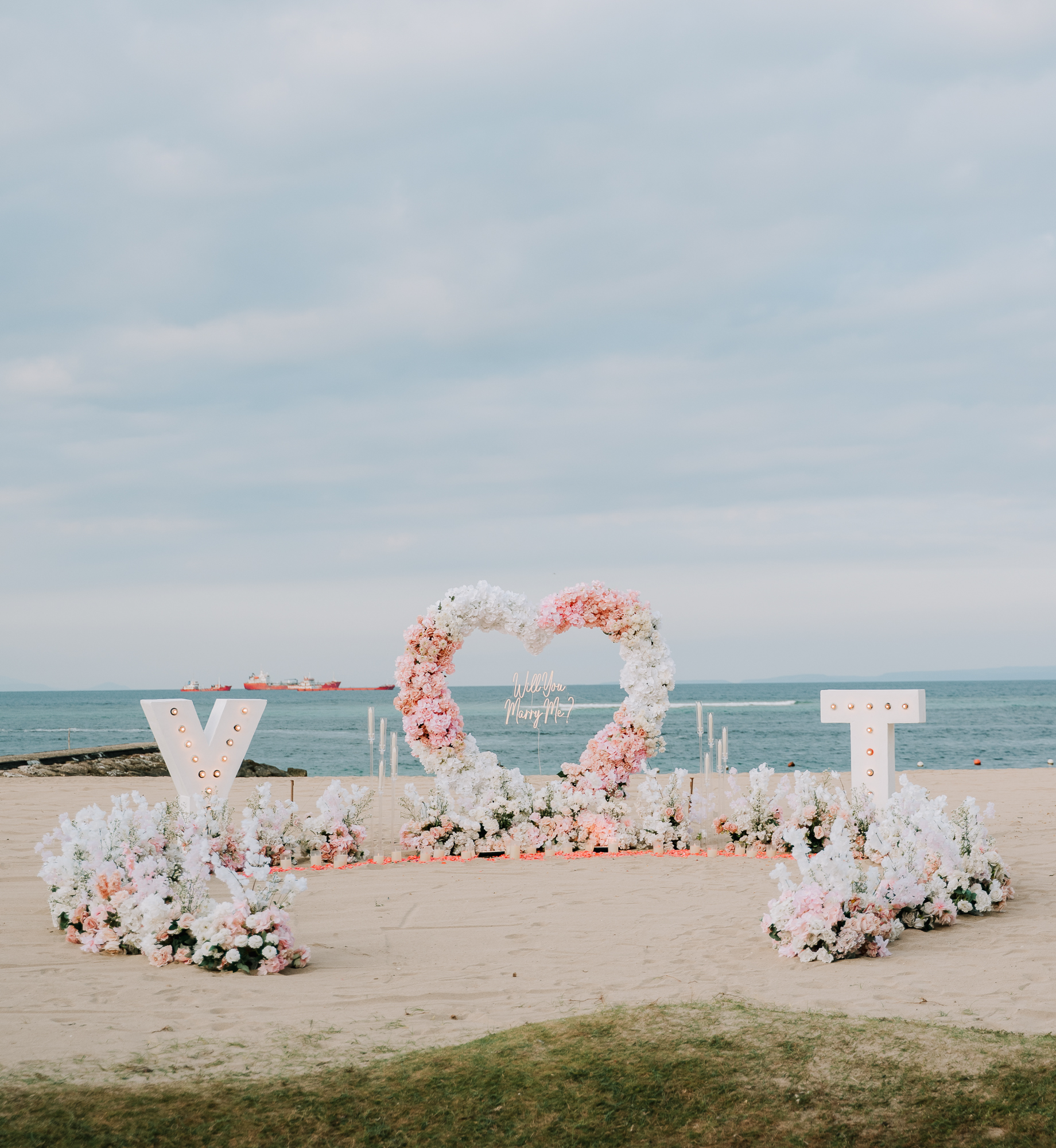 Custom luxury floral proposal arch set up on a secluded Bali cliffside.