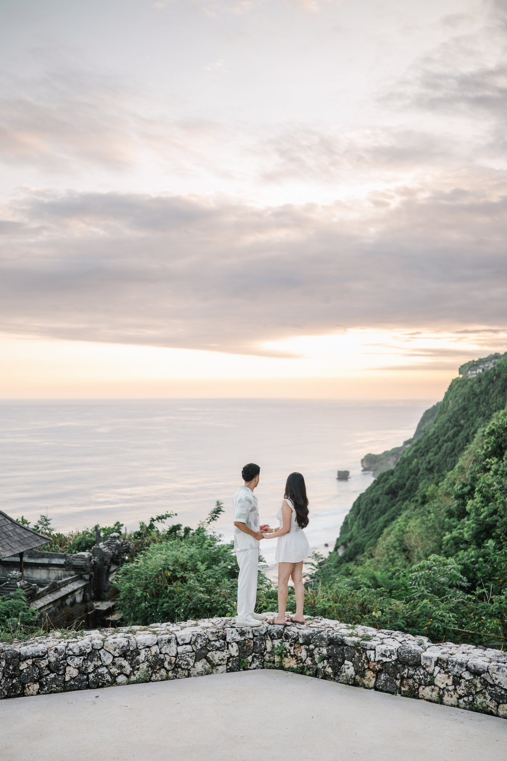 Newly engaged couple hugging in the sunlight during their private proposal photoshoot in Bali.