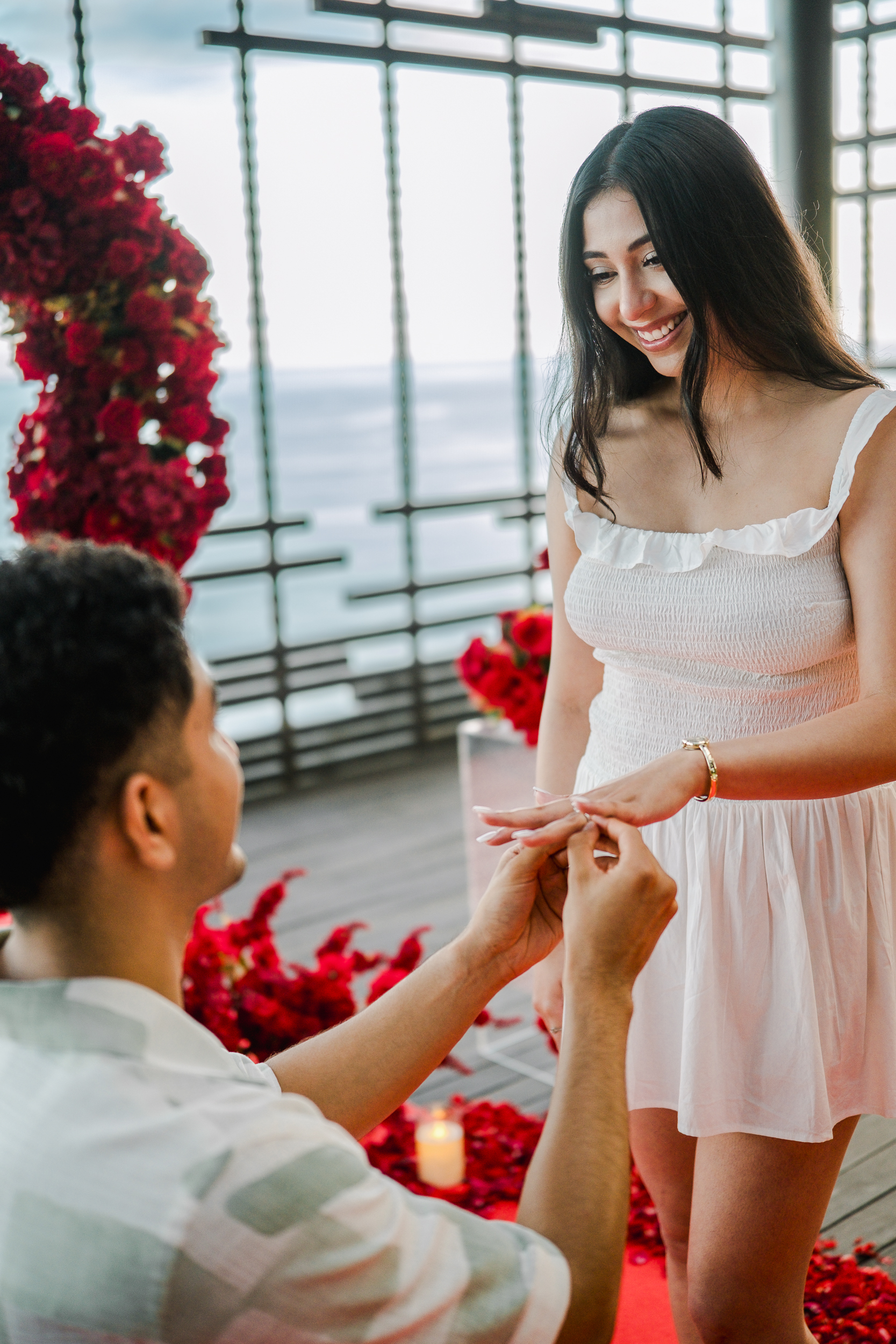 Groom dropping to one knee for a surprise helicopter proposal on a private Bali cliffside.