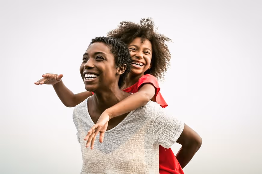 Trustworthy nanny and joyful child share a smile while embracing a fun-filled adventure, reflecting the heart of professional childcare and trusted nanny agency partnerships nationwide.