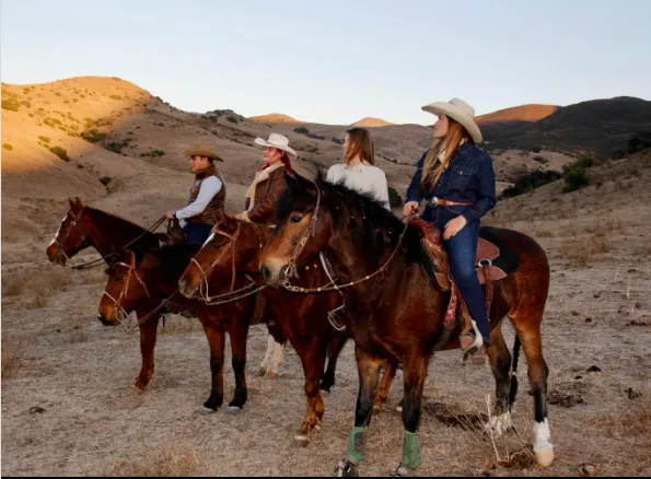 4 personas montando a caballo en un paisaje montañoso y seco un un clma despejado. Tijuana, La Ruta Vaquera, Baja California