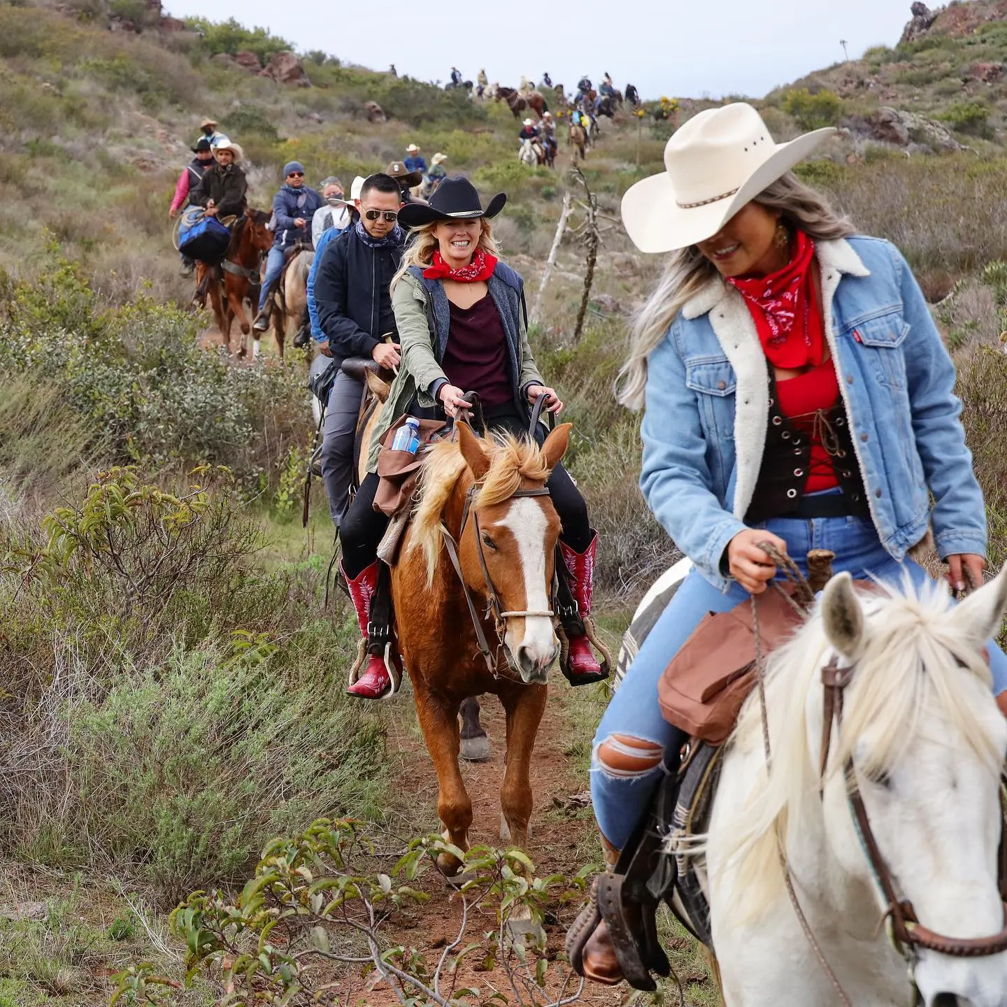 Un grupo de turistas cabalgando por el campo en carabana. La Ruta Vaquera, Baja California