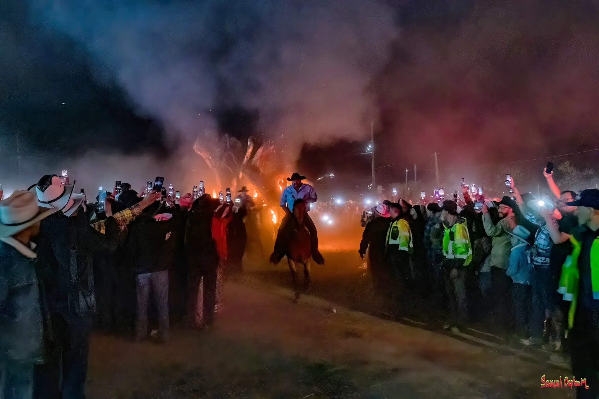 Una festividad en ensenada con humo , luces y mucha gente disfrutando a caballo en Ensenada. La Ruta Vaquera, Baja California