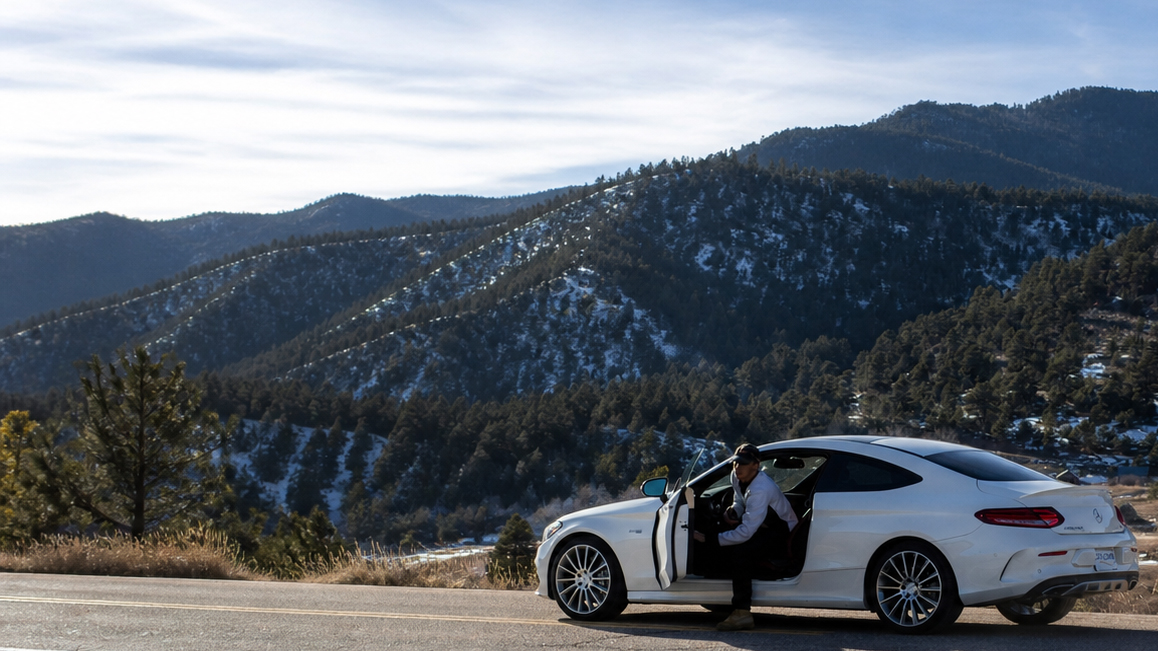 White Mercedes coupe parked on a Front Range mountain road