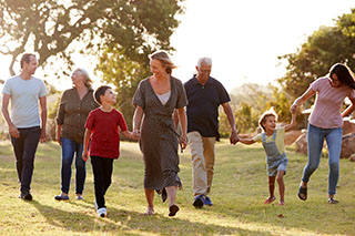 Multi-generational family walking together in a field