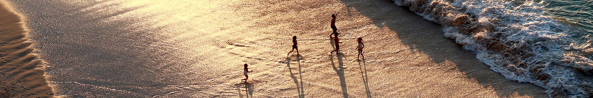 A family enjoying the beach at sunset