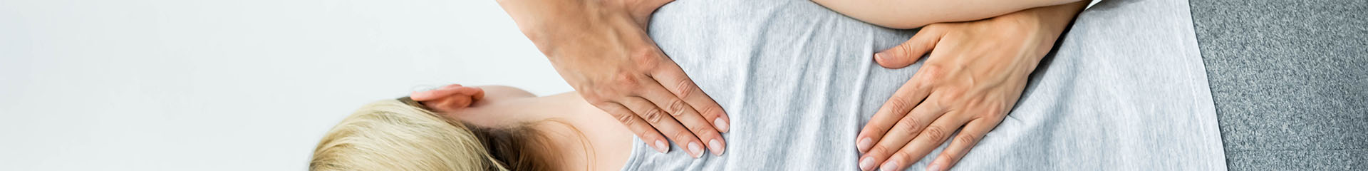 A woman on her side with the Chiropractor performing  their work