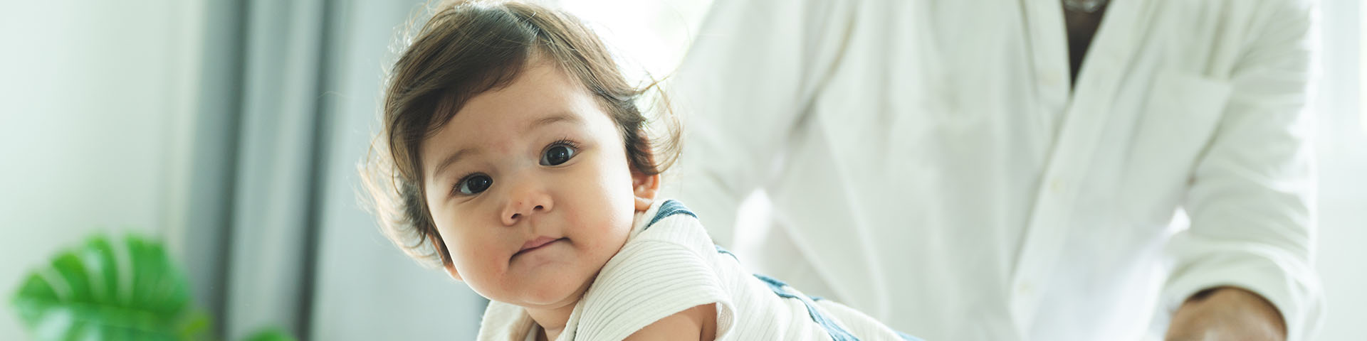 Child lying face down on a table receiving gentle spinal care from a chiropractor.