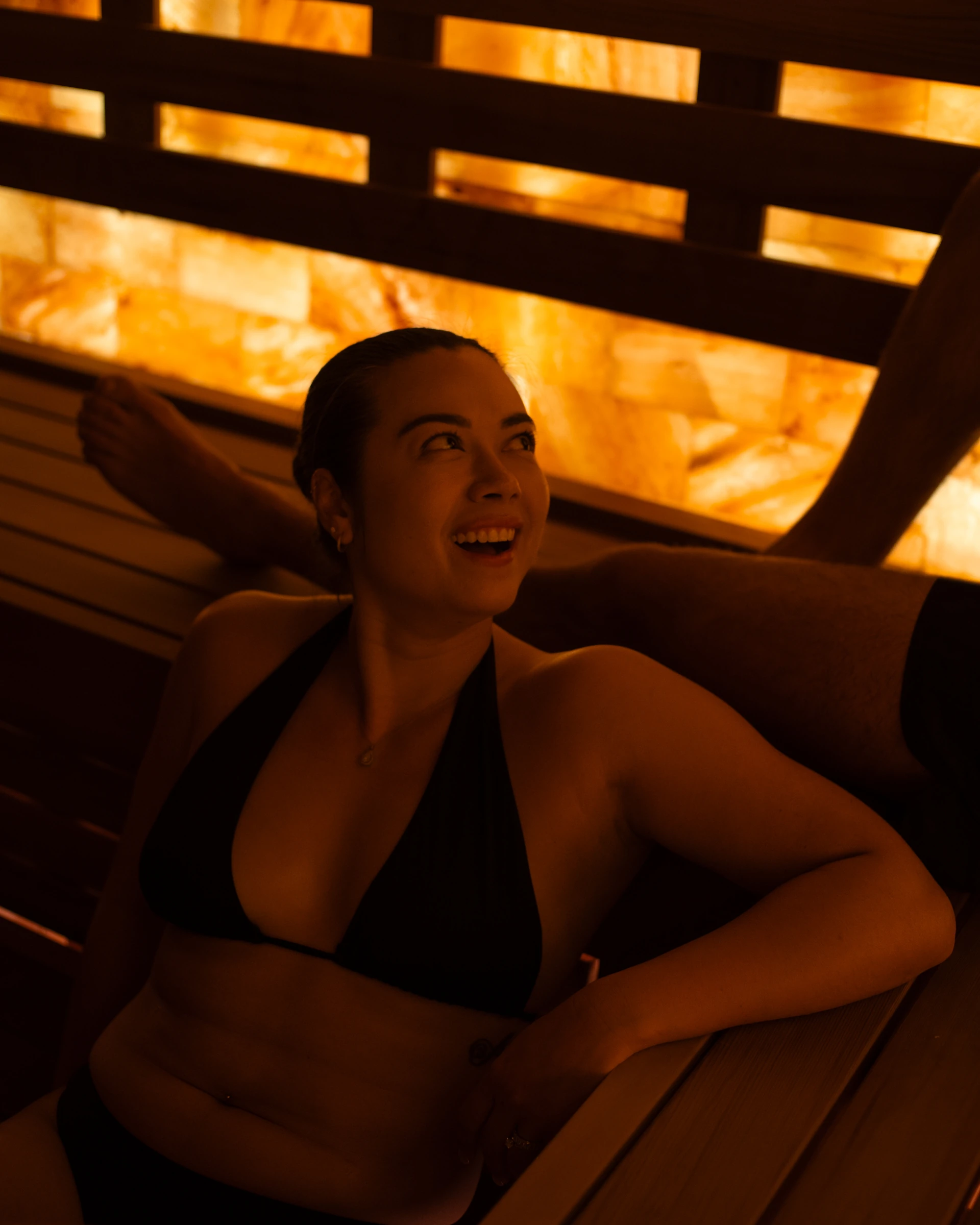 A couple enjoying sauna culture at AetherHaus in Vancouver with contemporary glowing Himalayan salt wall.