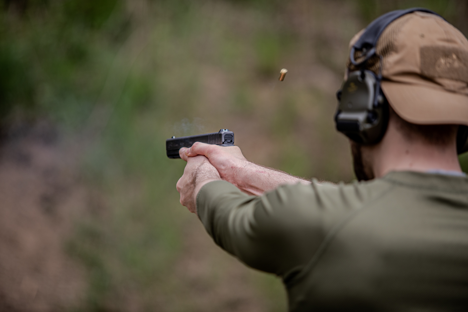 strzelec na strzelnicy, celujący w target, broń krótka, glock. 