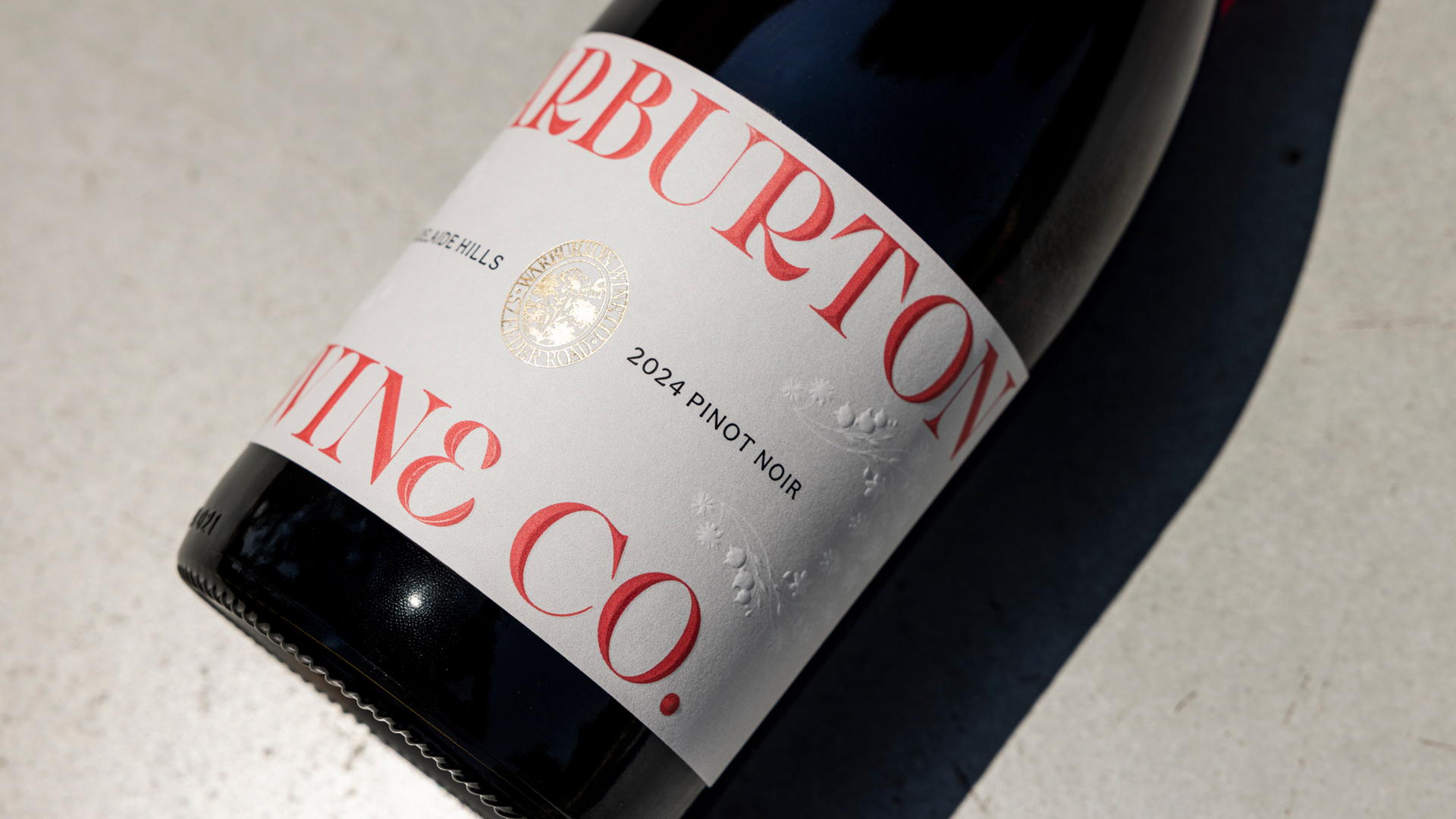 Minimal wine bottle on cream-toned surface.