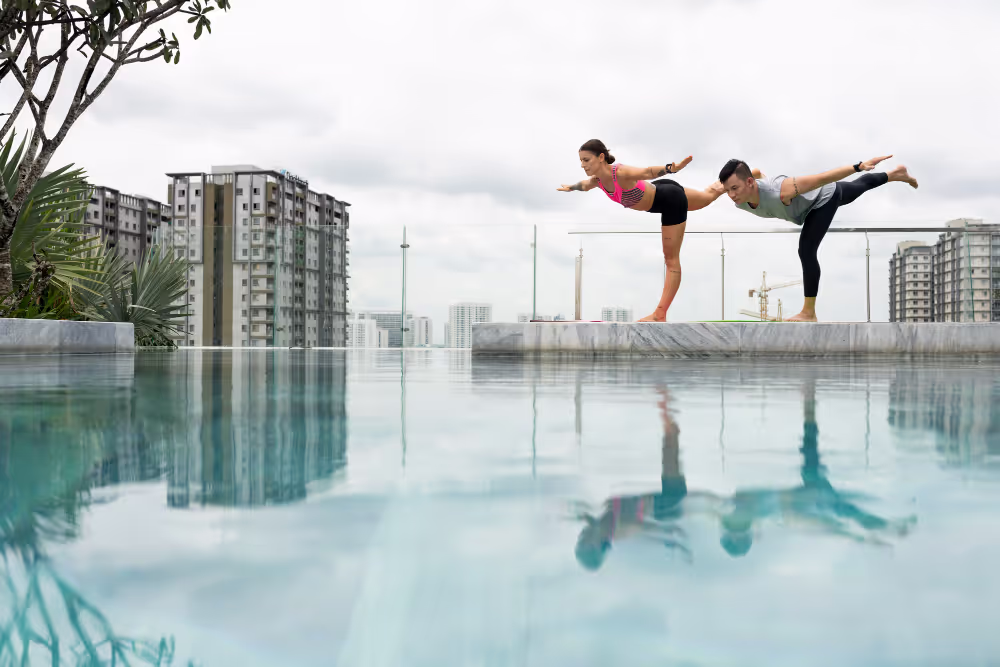 People doing yoga by the pool