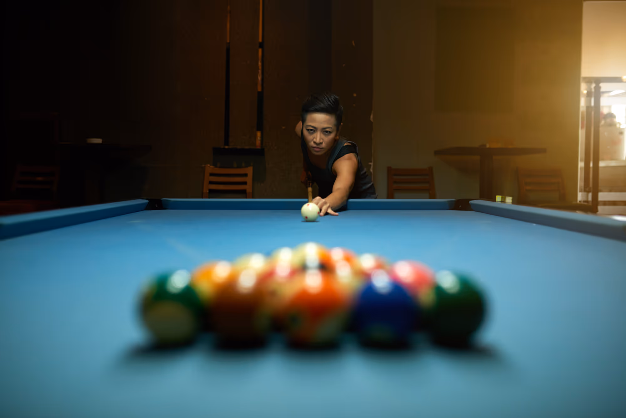 A woman is playing a game of pool.