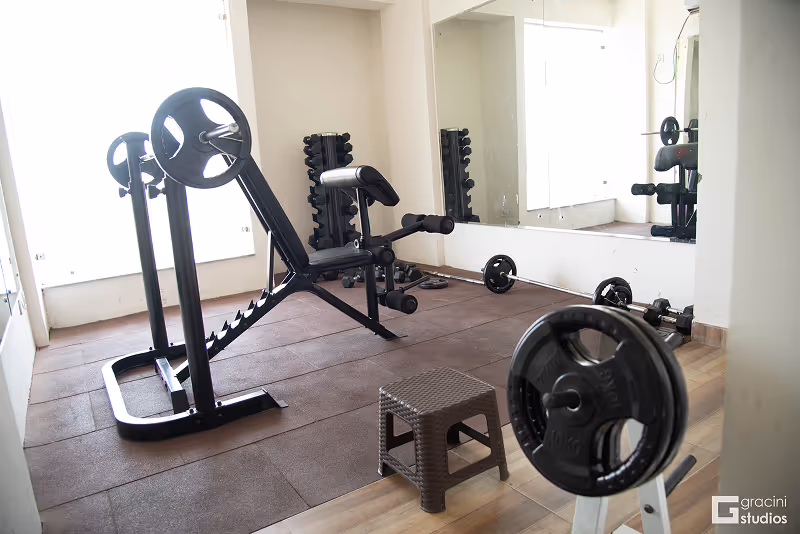 A gym with a weight machine and a mirror.