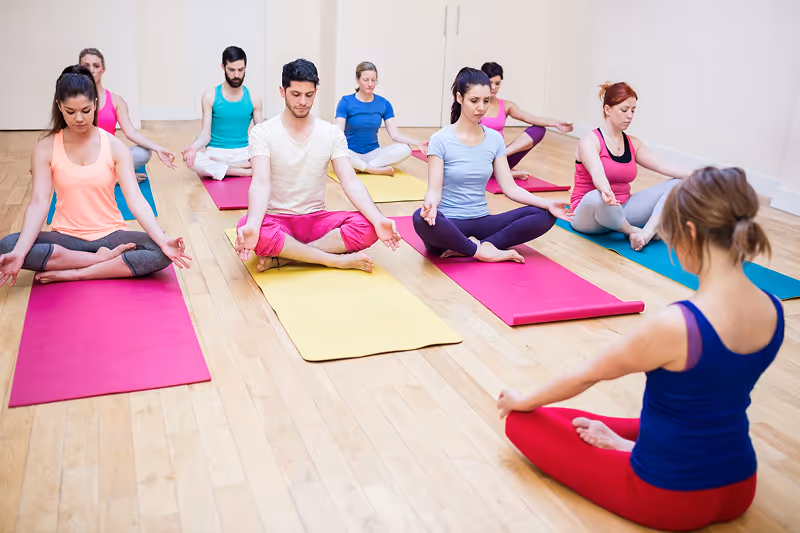 A group of people doing yoga in a room.