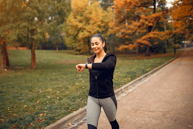 A woman is riding a skateboard in a park.