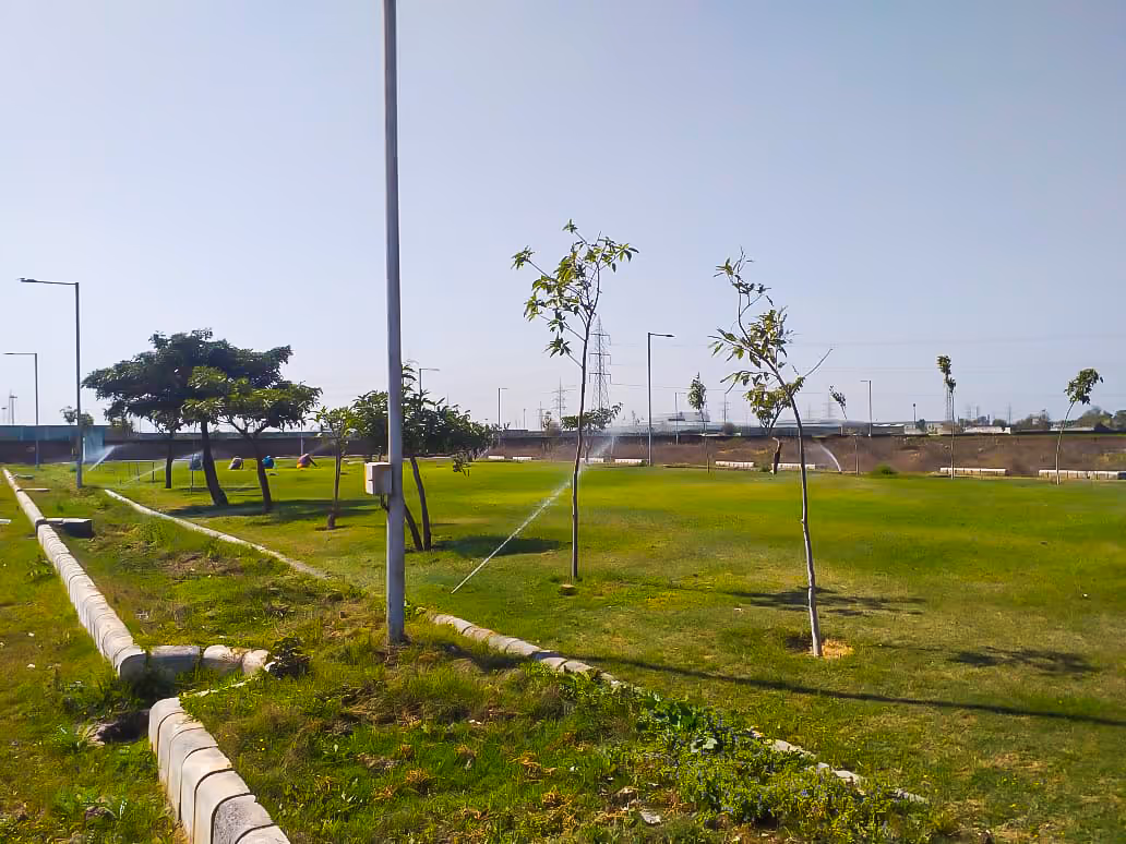 A green field with a fire hydrant in the middle of it.