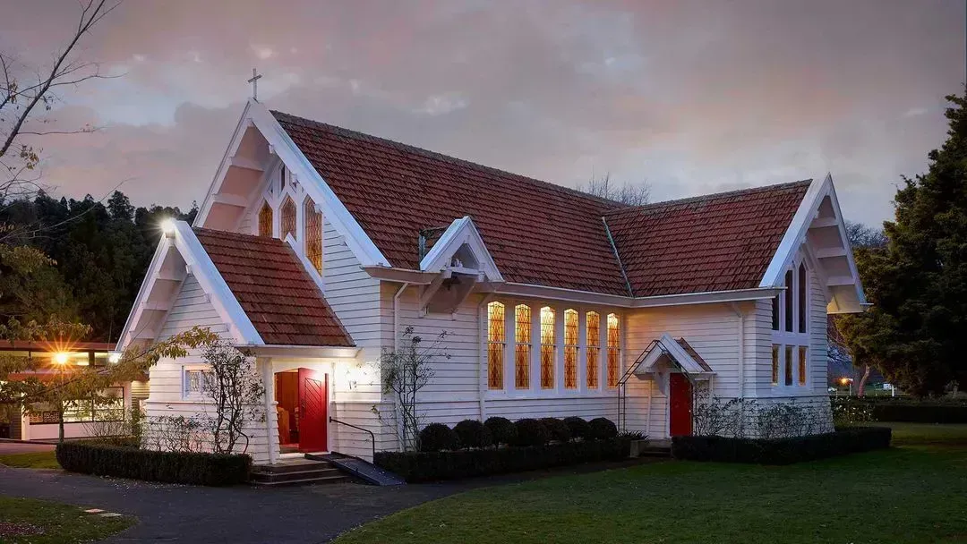 Alt text: "St. Peter's School chapel, a charming white building with stained glass windows and a red door, set against a peaceful evening sky. This notable site enhances the school’s vibrant community and spiritual life on campus."