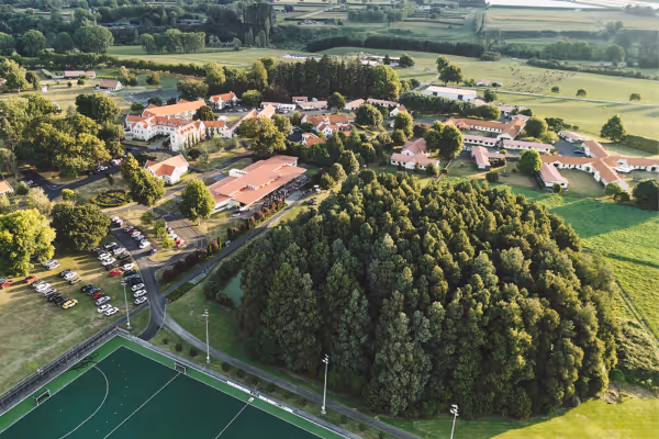 A group of three students hugging while out tramping