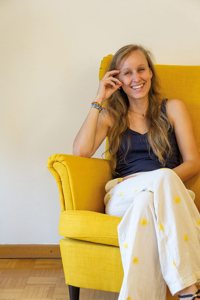 Portraitfoto Teresa Kirchengast in gelbem Sessel lachend