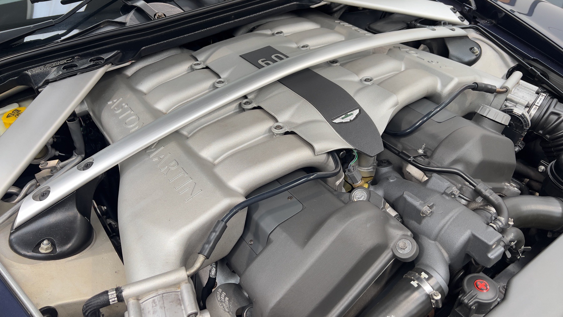 Close-up of the Aston Martin DB9's V12 cam covers and strut brace