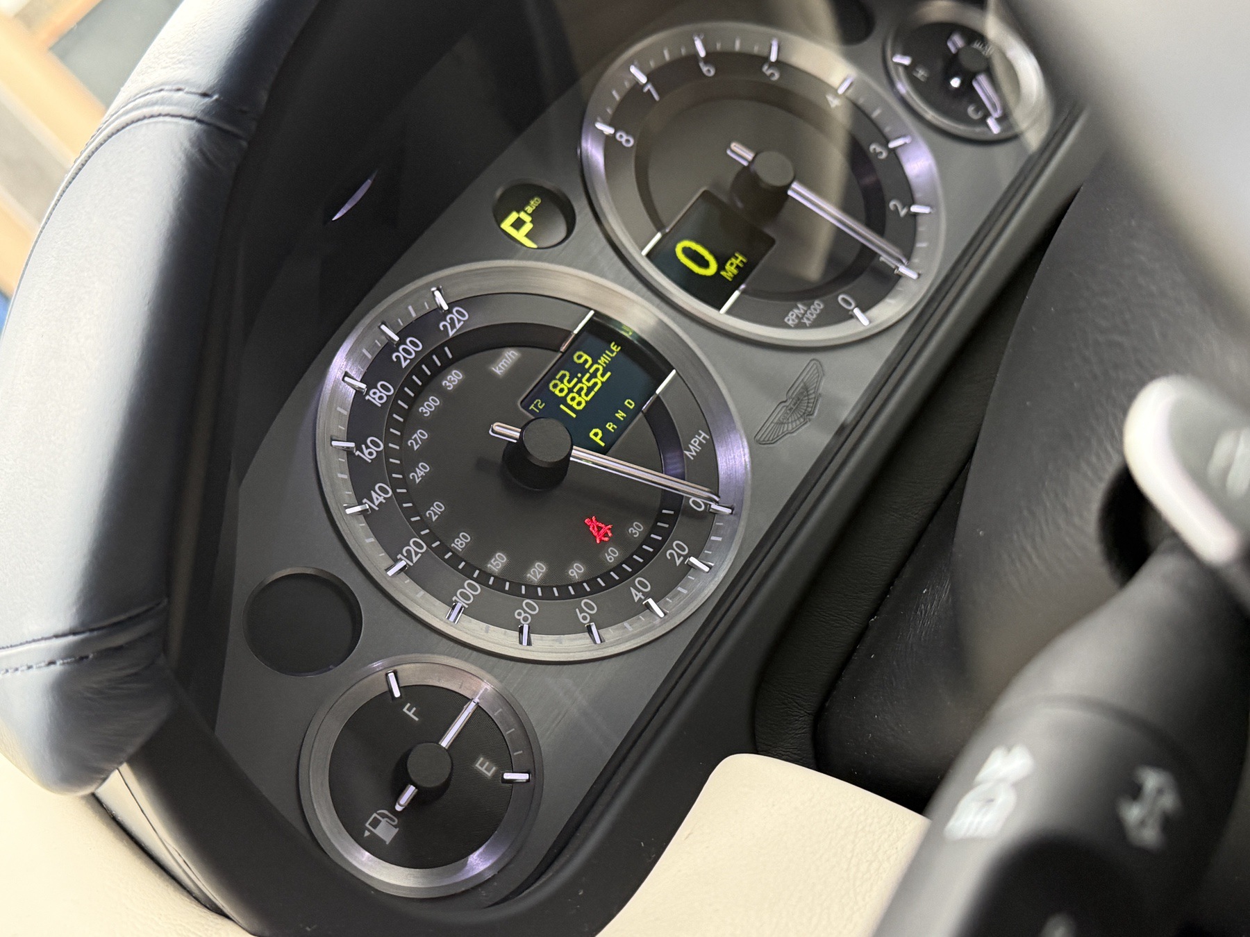 Aston Martin DB9 instrument binnacle viewed through the steering wheel