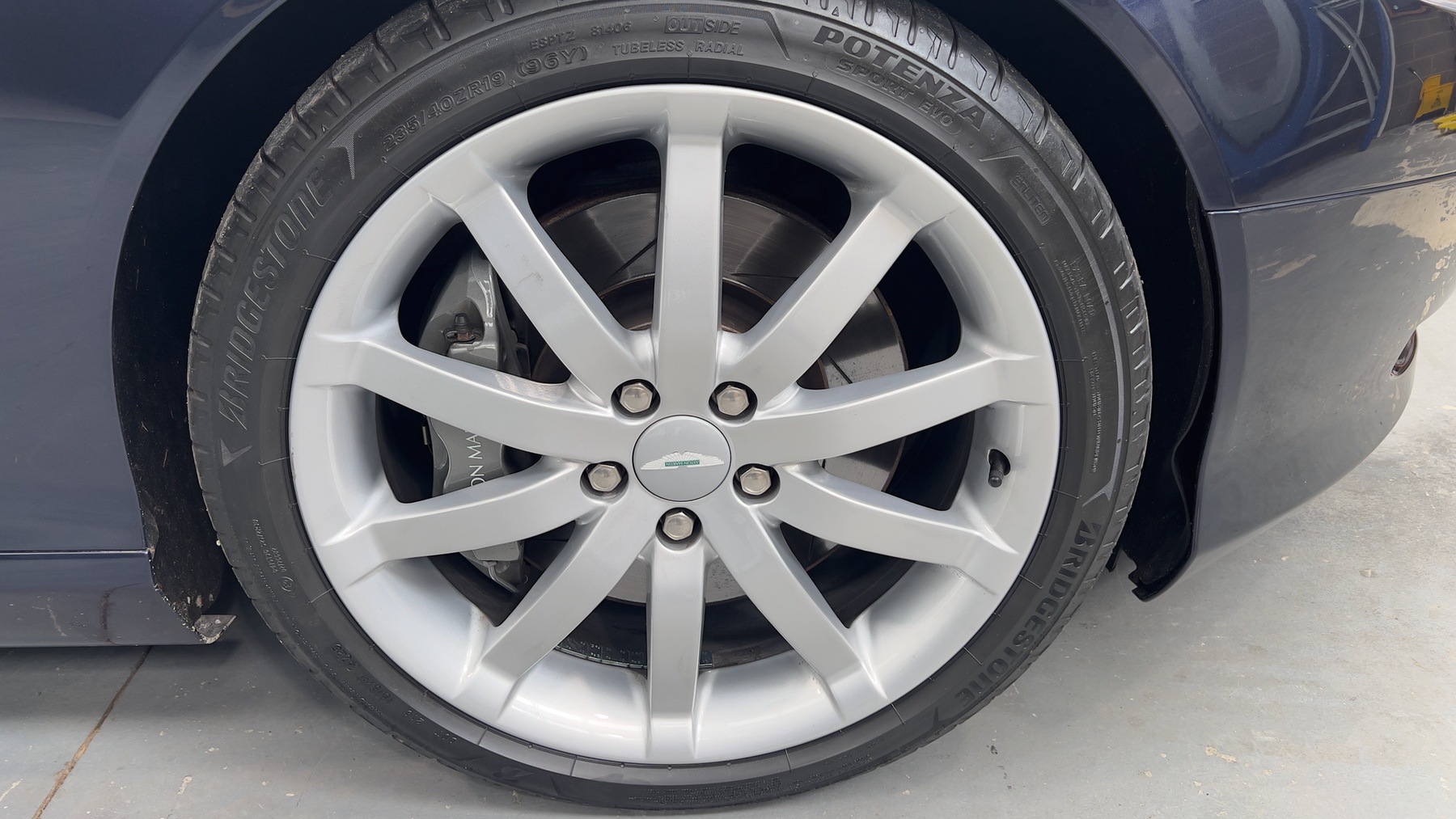 Alloy wheel and low-profile tyre on the Blue Sapphire Metallic Aston Martin DB9