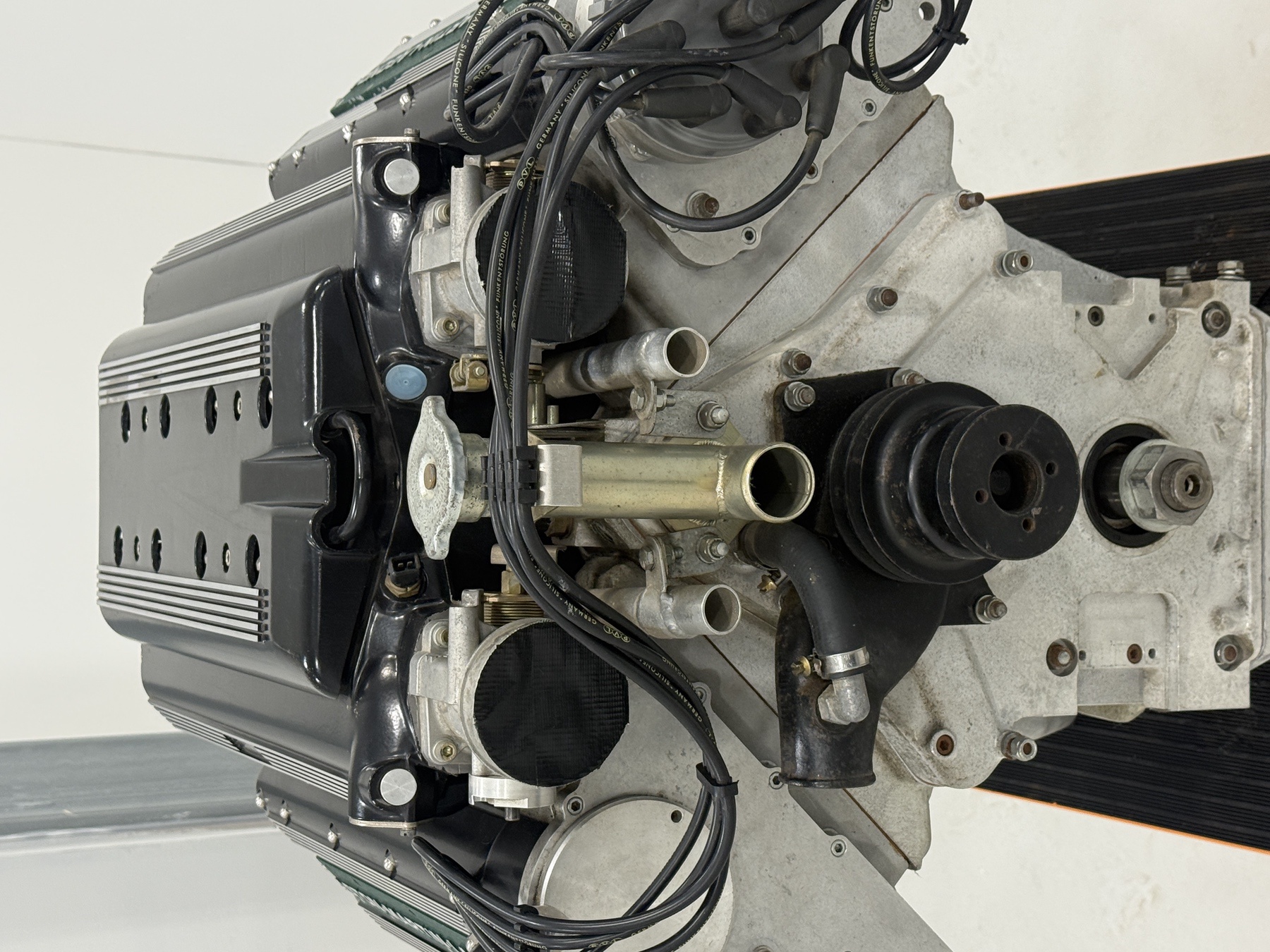 Front of the Aston Martin 7.3 litre V8 engine with coolant pipework and crank pulley