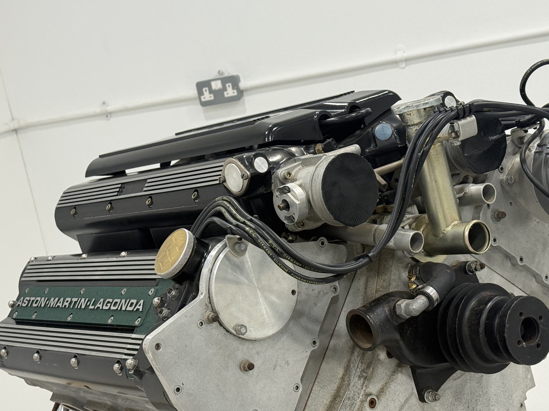 Top of the Aston Martin 7.3 litre V8 showing the throttle body, distributor and coolant pipework
