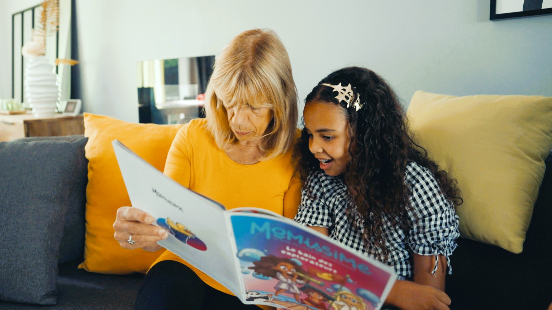 Une jeune fille lisant un magazine Mômissime avec sa grand-mère