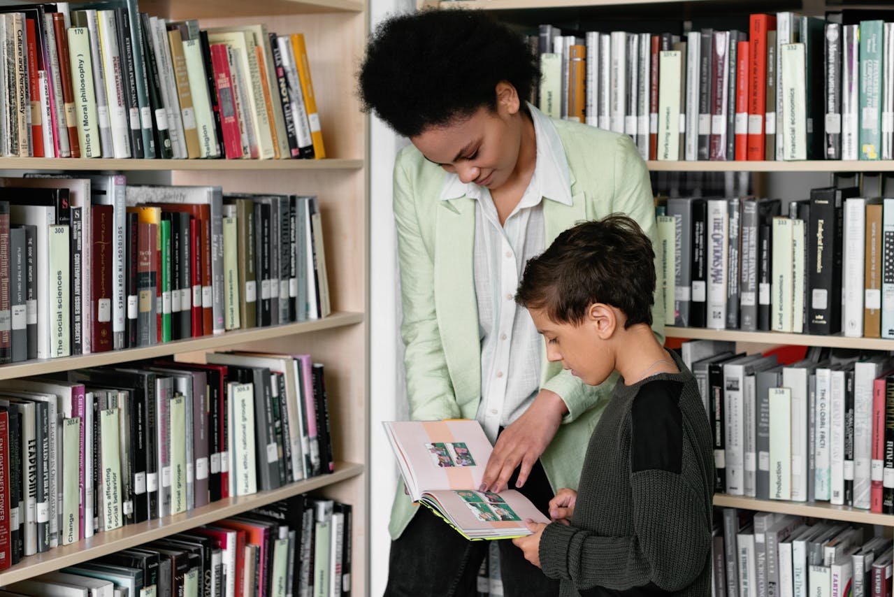 Une maman et son fils consultent des livres dans une bibliothèque