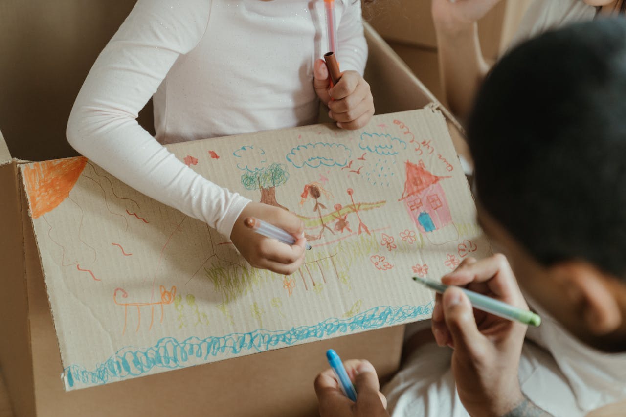 Deux enfants dessinent sur un carton