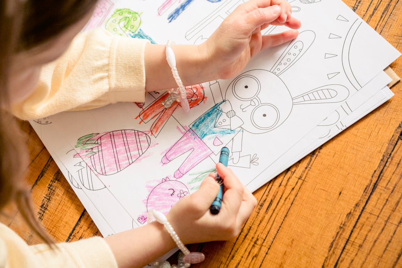 Une petite fille colorie un lapin à la craie grasse