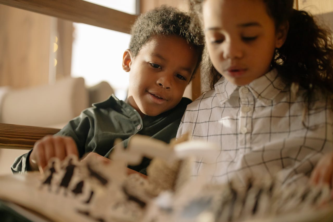 Deux enfants plongés dans la lecture d'un livre à relief