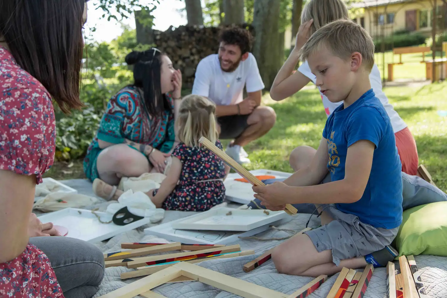 Des enfants et des adultes partagent un temps de jeux dans un parc extérieur