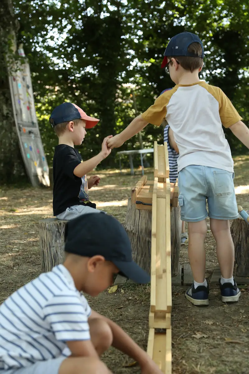 Des enfants partagent un temps de jeux dans un parc extérieur