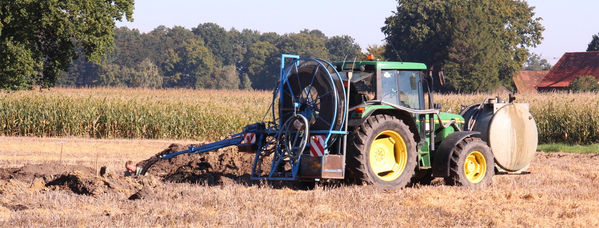 A green tractor with a blue and yellow plow.